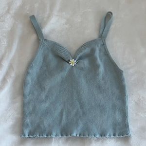 Medium Forever 21 Light blue tank top with daisy in the middle.